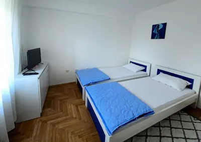 a bedroom with two beds and a television in it at Apartman Felix in Laktaši