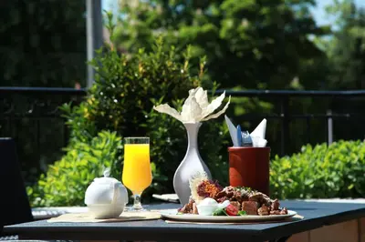 a table with a plate of food and a glass of orange juice at Provence rooms in Banja Luka