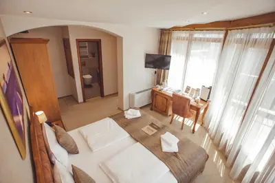 a bedroom with a large bed and a desk with a television at Provence rooms in Banja Luka
