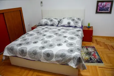 a bedroom with a bed with a comforter and pillows at Apartman MAŠA in Banja Luka