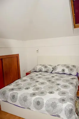 a bedroom with a bed with a comforter and two pillows at Apartman MAŠA in Banja Luka