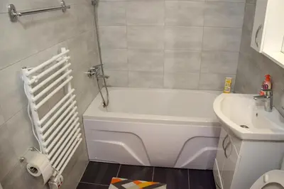 a bathroom with a white bath tub next to a sink at Apartman MAŠA in Banja Luka