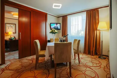 a dining room with a table and chairs in a hotel room at Grand Hotel Tuzla in Tuzla