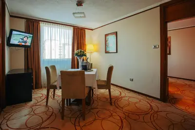 a dining room with a table and a television at Grand Hotel Tuzla in Tuzla
