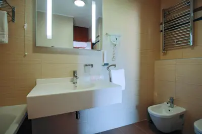 a bathroom with a white sink and a toilet at Grand Hotel Tuzla in Tuzla