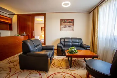 a living room with two leather chairs and a table at Grand Hotel Tuzla in Tuzla