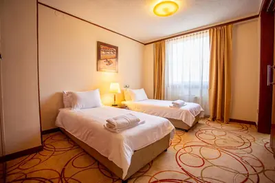 a hotel room with two beds and a window at Grand Hotel Tuzla in Tuzla
