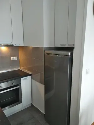 a kitchen with white cabinets and a stainless steel refrigerator at Centar Banja Luka Apartman MIKI in Banja Luka