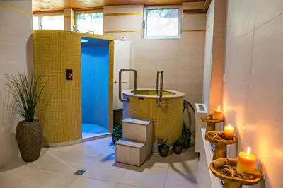 a bathroom with a jacuzzi tub with two candles at Hotel San Terme Laktaši in Laktaši