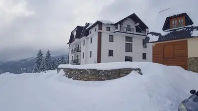 a building with a pile of snow in front of it at Apartments Vlašić in Vlasic