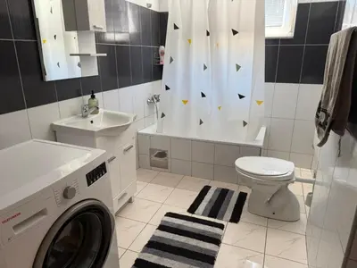 a bathroom with a washing machine and a sink at Vela-edo in Zavidovići