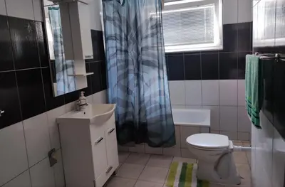 a bathroom with a sink and a toilet and a window at Vela-edo in Zavidovići
