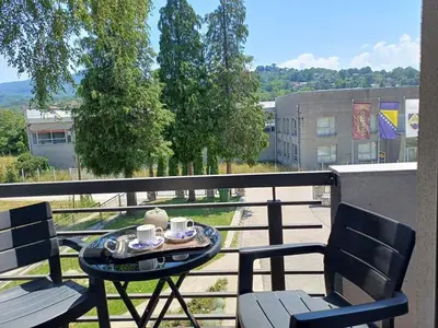 a table and two chairs on a balcony with coffee cups at Vela-edo in Zavidovići