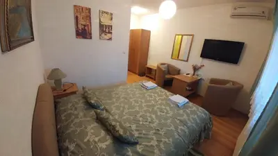 a small bedroom with a bed and a television at Vila San in Banja Luka