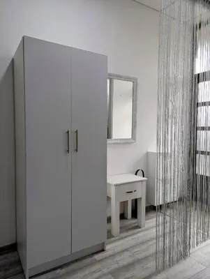 a white cabinet in a room with a mirror at Vila San in Banja Luka