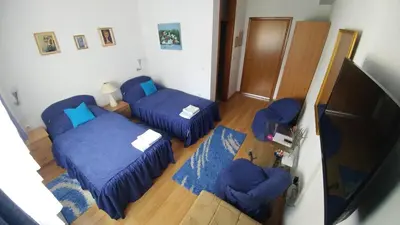 a room with two beds and a flat screen tv at Vila San in Banja Luka