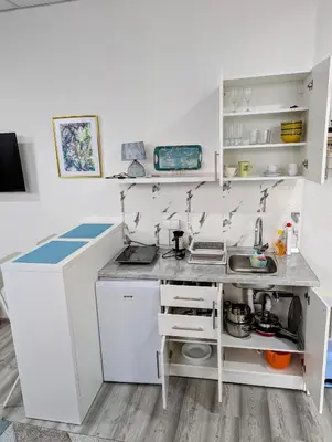 a small kitchen with white cabinets and a sink at Vila San in Banja Luka