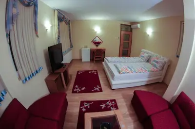 a living room with a bed and a tv at Hotel Fontana in Zenica
