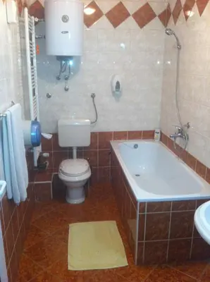 a bathroom with a tub and a toilet and a sink at Hotel Fontana in Zenica