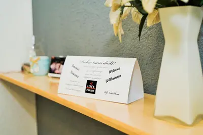 a sign sitting on a table next to a vase at Lola's House in Jajce