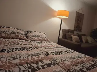 a bedroom with a bed and a lamp and a couch at Stan-apartman A&A in Banja Luka