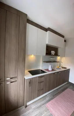 a kitchen with wooden cabinets and a sink at Stan-apartman A&A in Banja Luka