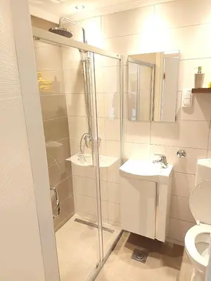 a bathroom with a shower and a sink and a toilet at Stan-apartman A&A in Banja Luka