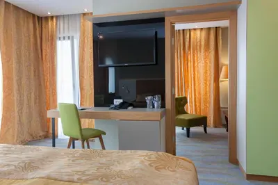 a hotel room with a bed and a desk with a television at Hotel Opal Exclusive Bihać in Bihać