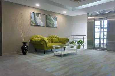 a living room with a green couch and a table at Hotel Opal Exclusive Bihać in Bihać
