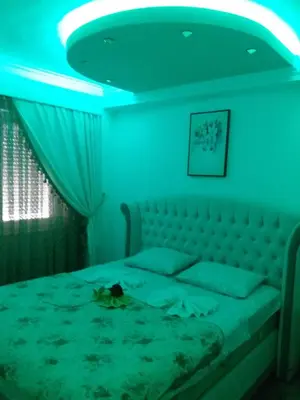a bedroom with a bed with a blue light at Apartman Tea 2 in Banja Luka