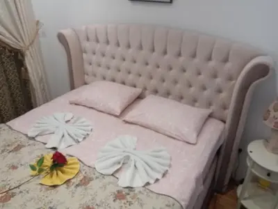 a bed with white pillows and flowers on it at Apartman Tea 2 in Banja Luka