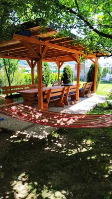 a wooden gazebo with benches in a park at Medif apartments in Visoko