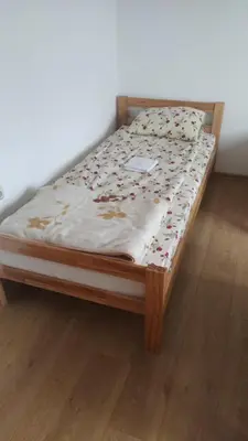 a bed sitting on a wooden floor in a room at Medif apartments in Visoko