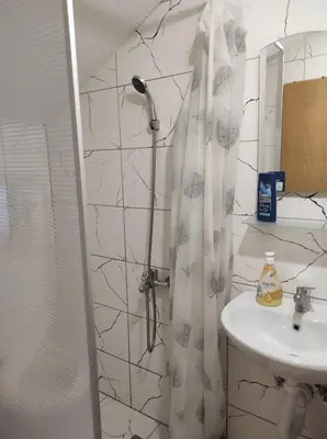 a bathroom with a shower curtain and a sink at Medif apartments in Visoko