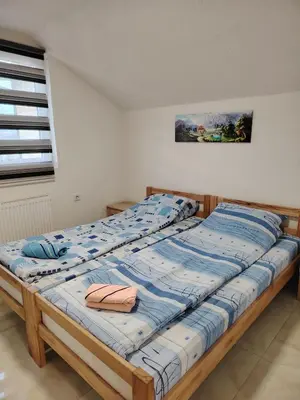 a bed with a blue comforter in a room at Medif apartments in Visoko