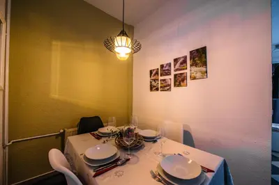 a dining room table with a white table cloth and a light at Apartman Luka in Livno