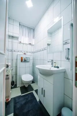 a white bathroom with a sink and a toilet at Apartman Luka in Livno