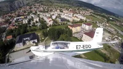 a small plane is flying over a city at Apartman Luka in Livno