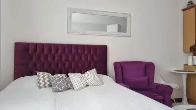 a bed with a purple headboard and a purple chair at Vlašićka idila apartman Eko Fis 507 in Vlasic
