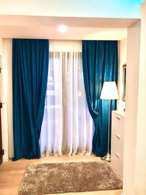 a living room with blue curtains and a window at Moonlight Visoko in Visoko