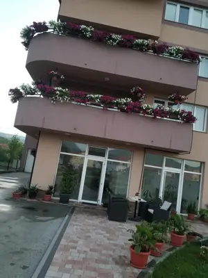 a building with potted plants on the side of it at Apartmani Kadunić in Bugojno