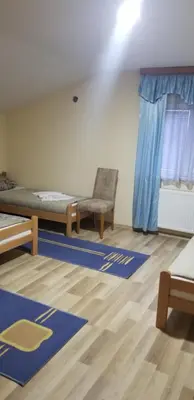 a room with a bed and a chair and blue mats at Apartmani Kadunić in Bugojno