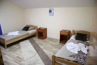 a room with two beds and two night stands at Apartmani Kadunić in Bugojno