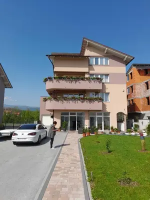 a man walking in front of a building at Apartmani Kadunić in Bugojno