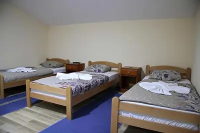 a room with three beds in a room at Apartmani Kadunić in Bugojno
