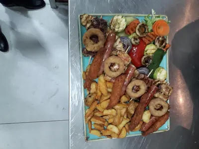 a plate of different types of food on a table at Hotel Rafaelo in Bosanska Dubica
