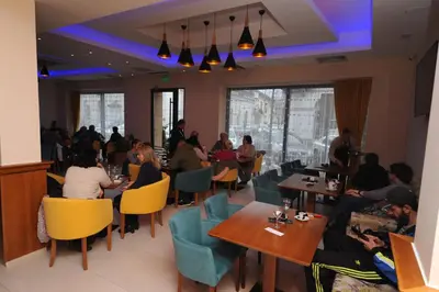 a group of people sitting at tables in a restaurant at Hotel Rafaelo in Bosanska Dubica