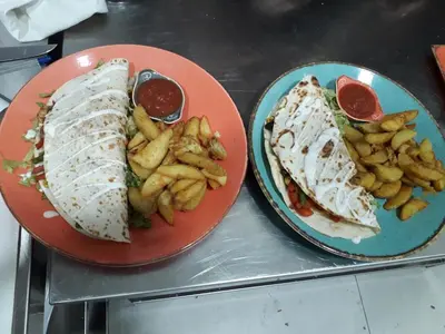 two plates of food with a sandwich and french fries at Hotel Rafaelo in Bosanska Dubica