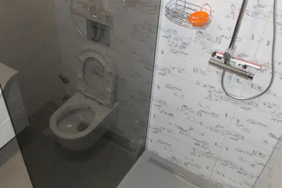 a bathroom with a toilet with writing on the wall at Oasis of peace in Bihać