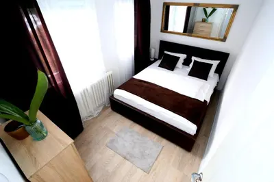 a small bedroom with a bed and a mirror at Apartman City Lux in Banja Luka